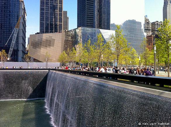 A view of the north World Trade Center pool with the 9/11 Memorial Plaza and Memorial Museum in the background