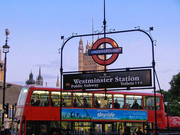 Typical London scene of an Underground station, red double-decker bus and Westminster Palace
