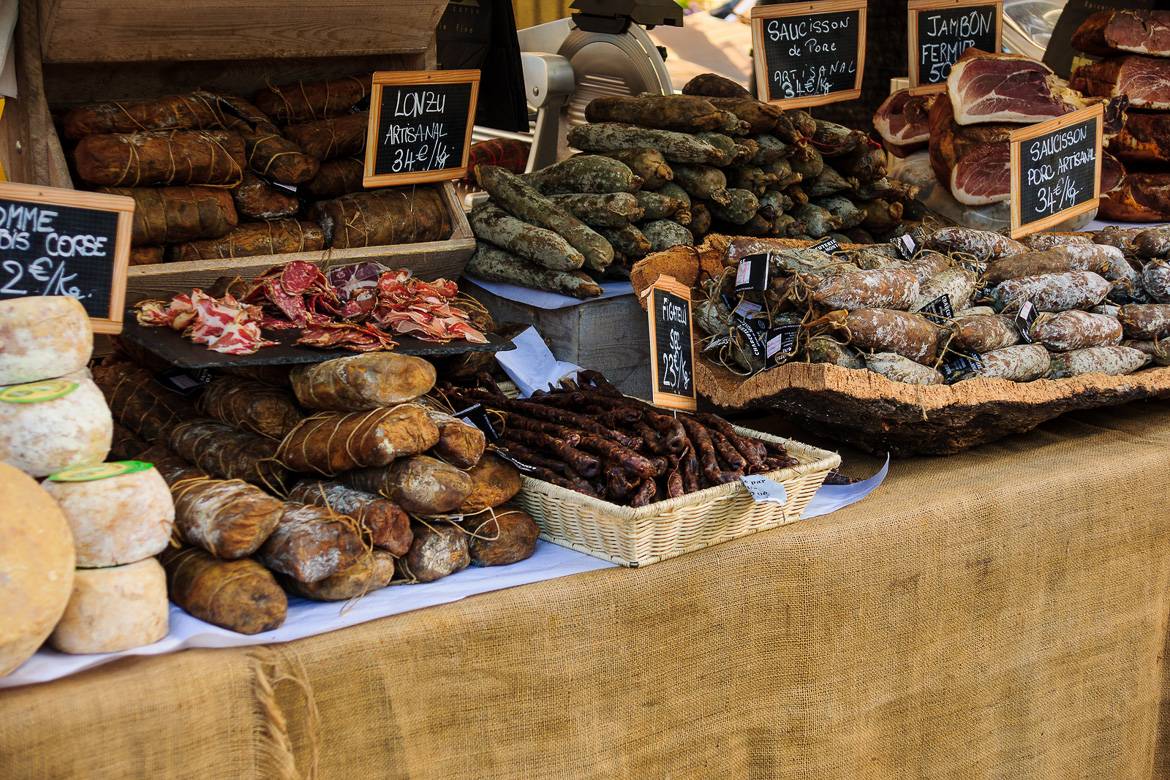 Image of a table laden with sausages, cheeses and French specialties