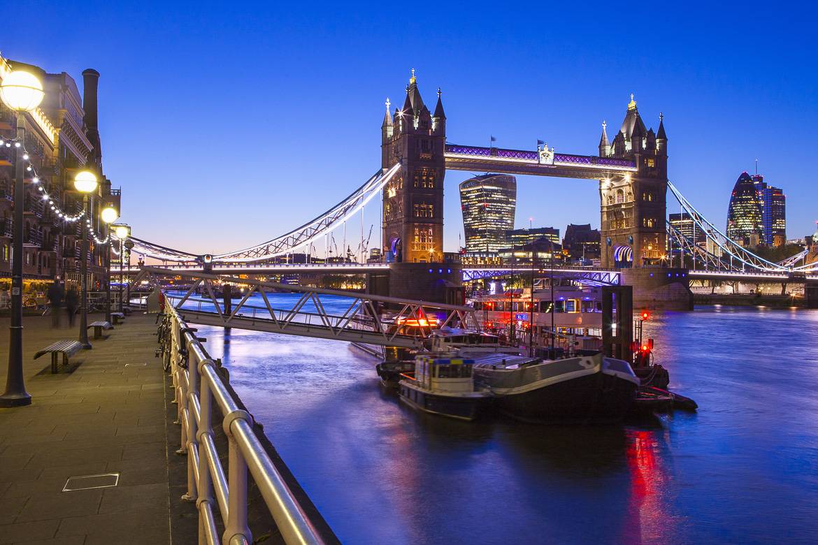 Image of a boat docked on the side of the River Thames near Tower Bridge in London