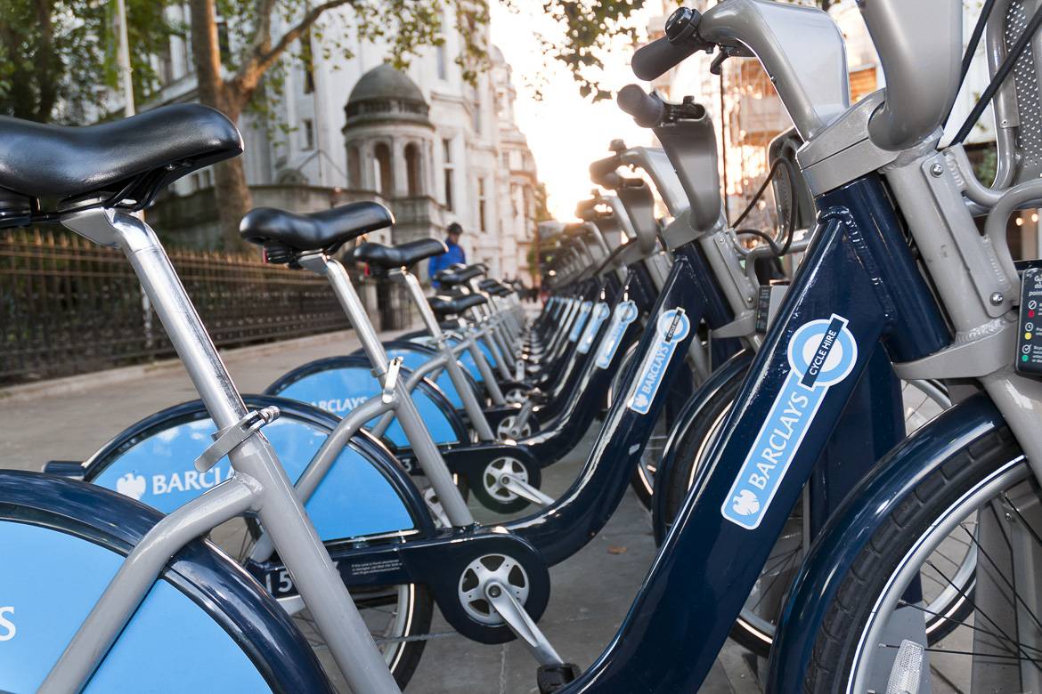 Image of blue Barclay’s bicycles on a London sidewalk lined up in a row