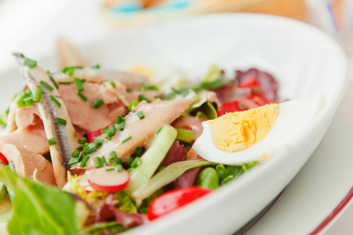 Image of a white plate with salade niçoise