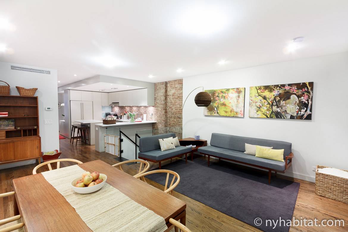 Image of an open apartment living area with a kitchen, dining table and decorative colors