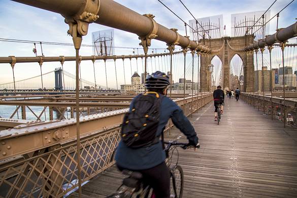 Image of people biking over Brooklyn Bridge