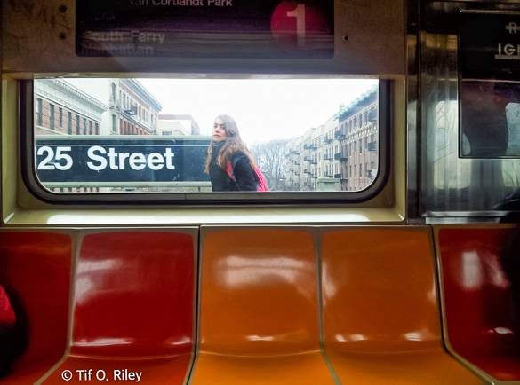 Image of an elevated subway station with a woman on the platform .