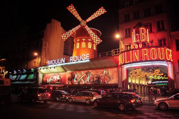 Night shot of the Moulin Rouge with red lights and windmill on top