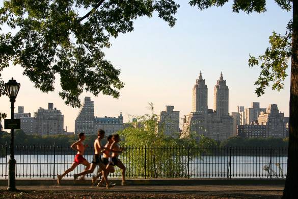 Image of joggers running alongside the Central Park reservoir at sunset