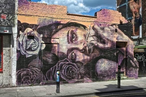 Image of woman’s face spray painted on the side of a building