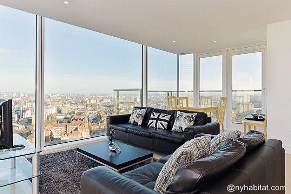 Image of black leather couches looking out over London’s skyline through a wall of windows