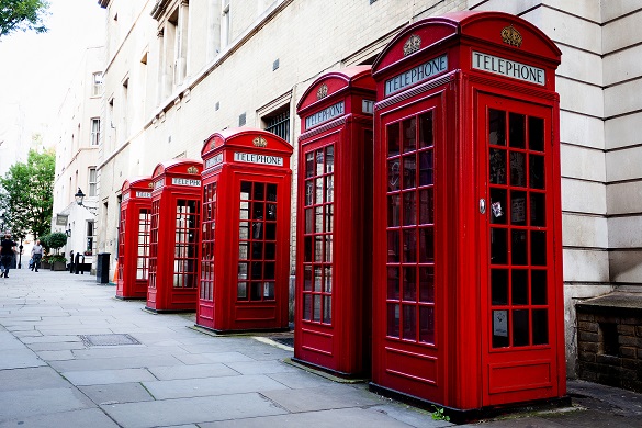 Image of multiple red London telephone booths lining a street