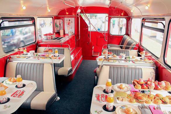Image of the interior of a red London bus converted into a small restaurant