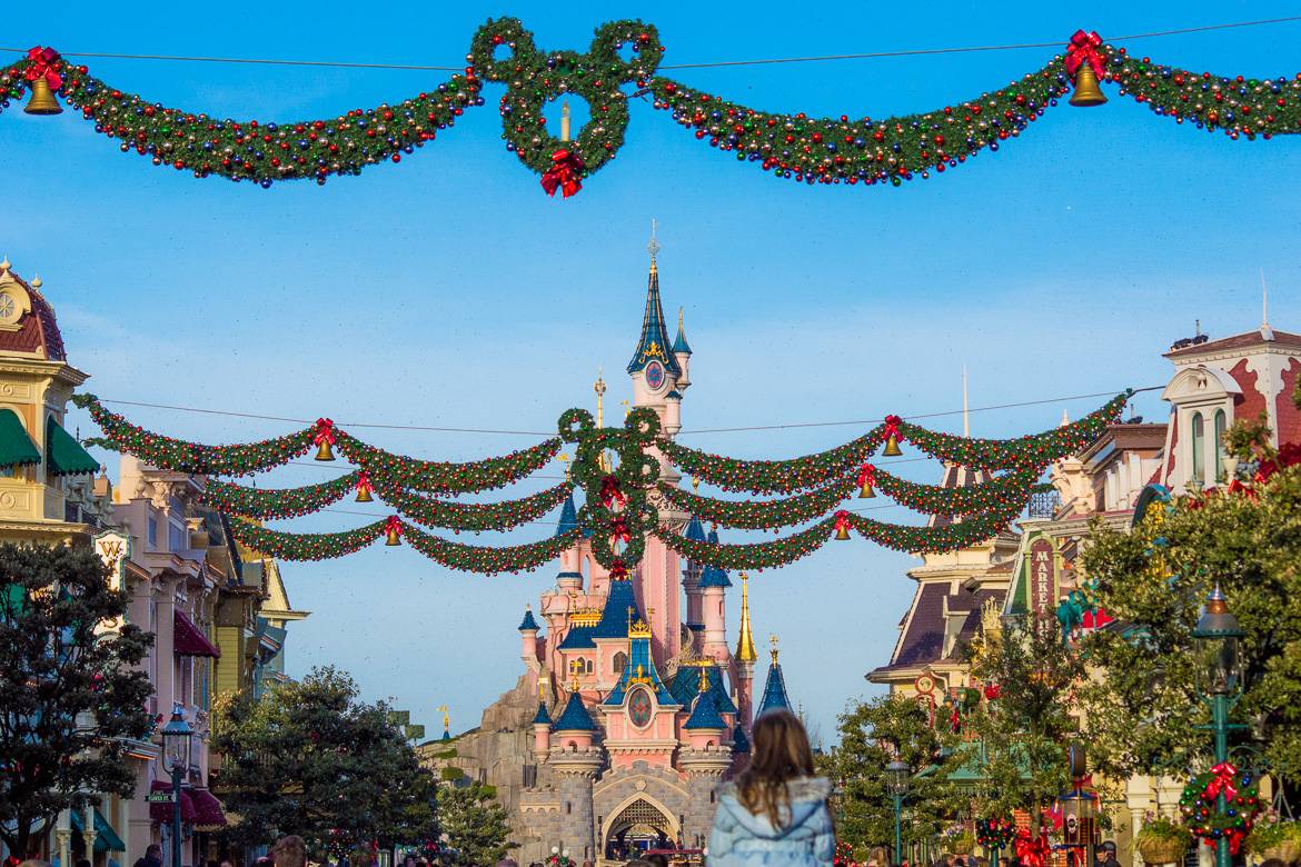 Image of Cinderella’s Castle at Disneyland Paris with Christmas wreaths in the shape of Mickey Mouse lining the street