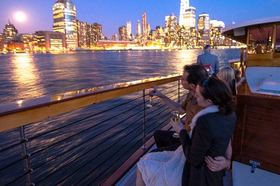 Image of people on a yacht cruise with NYC skyline in the background