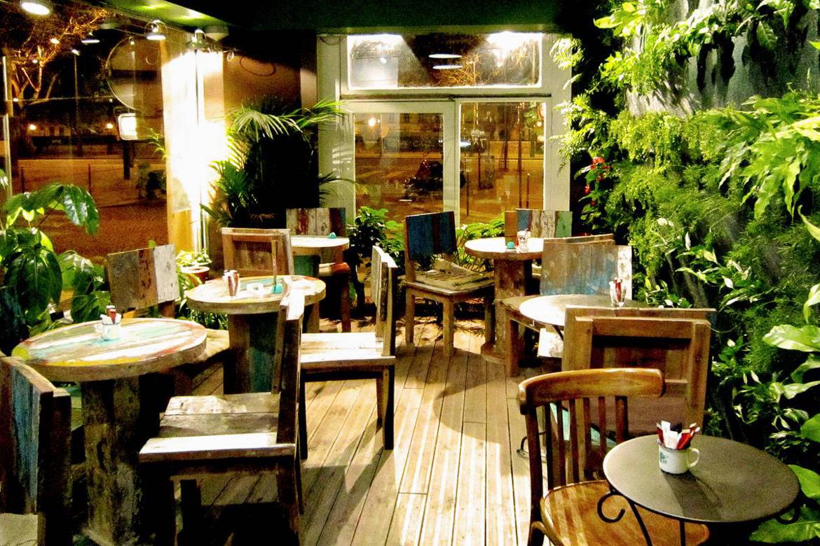 Image of La Caféothèque coffee spot with plants lining the walls