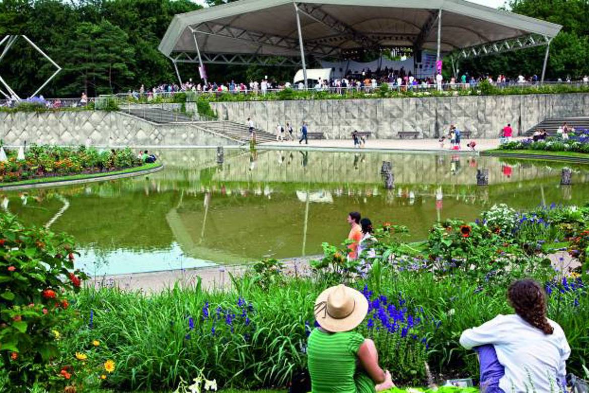 Image of people sitting among plants and flowers at a park in Paris