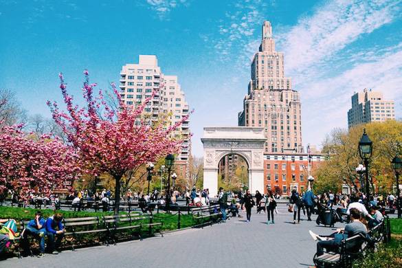 Image of arch in Washington Square Park in Greenwich Village with flowering trees and benches