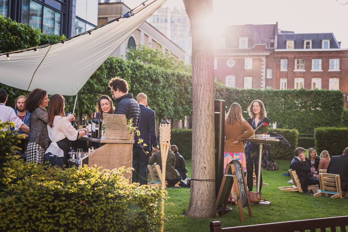 Image of people drinking wine outdoors in a grassy area