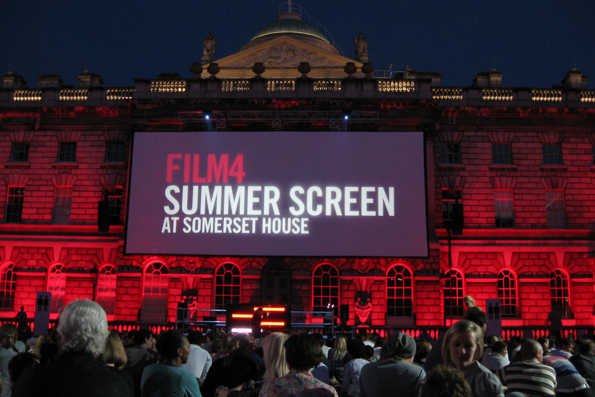 Image of Somerset House in London with movie screen on the façade and moviegoers in the foreground