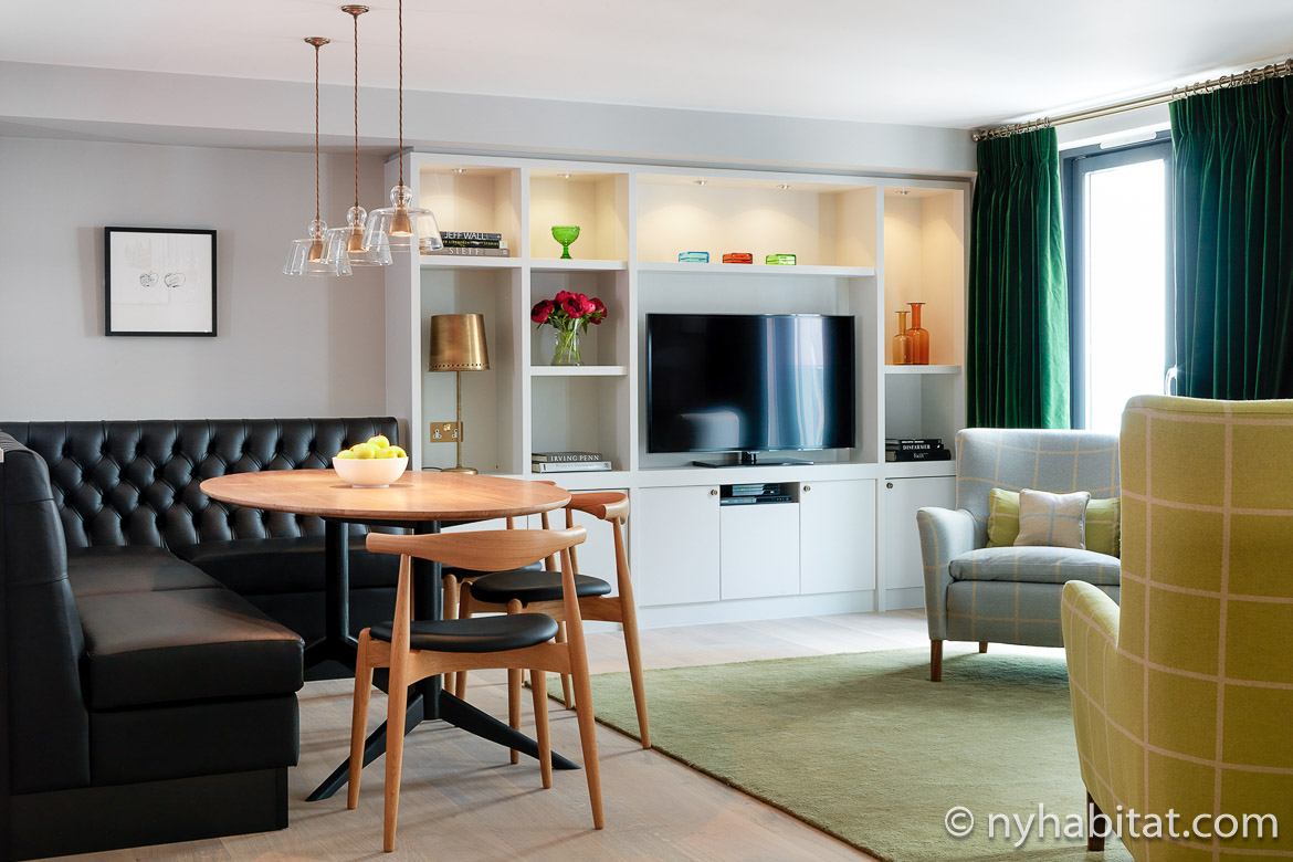 Image of living room of LN-812 in Knightsbridge with dining area, leather booth seating and television