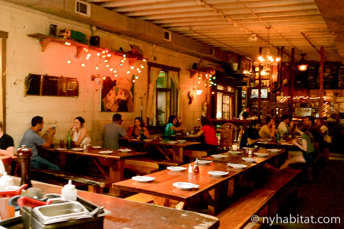 Image of young people enjoying food and drinks at a bar in Bushwick, Brooklyn.