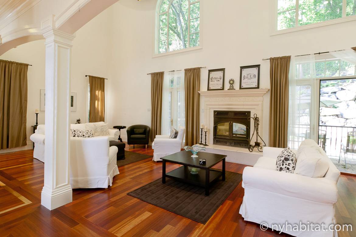 Image of parlor in NY-15040 with fireplace, floor-to-ceiling windows and white seating.