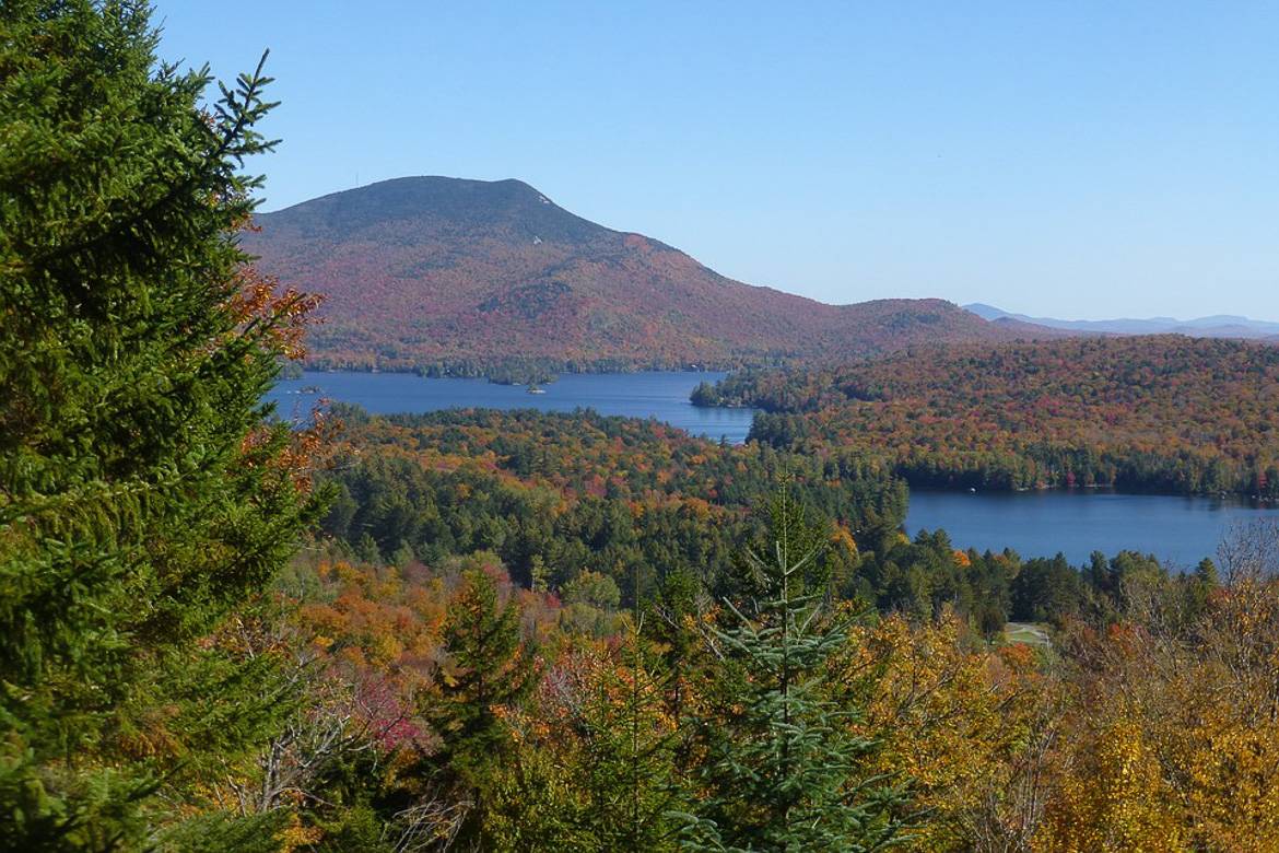 Image of Adirondack Mountains surrounding a lake in autumn.