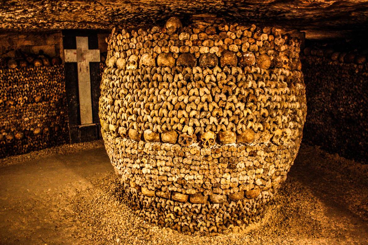 Image of column made of human skulls and bones in the Catacombs of Paris.