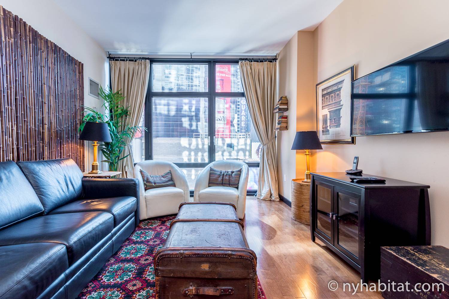 Image of living area of NY-14951 with sofa, armchairs and window.