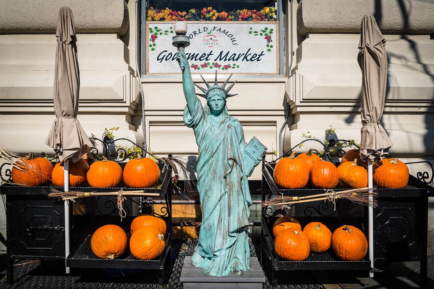 Image of a miniature Statue of Liberty surrounded by pumpkins.