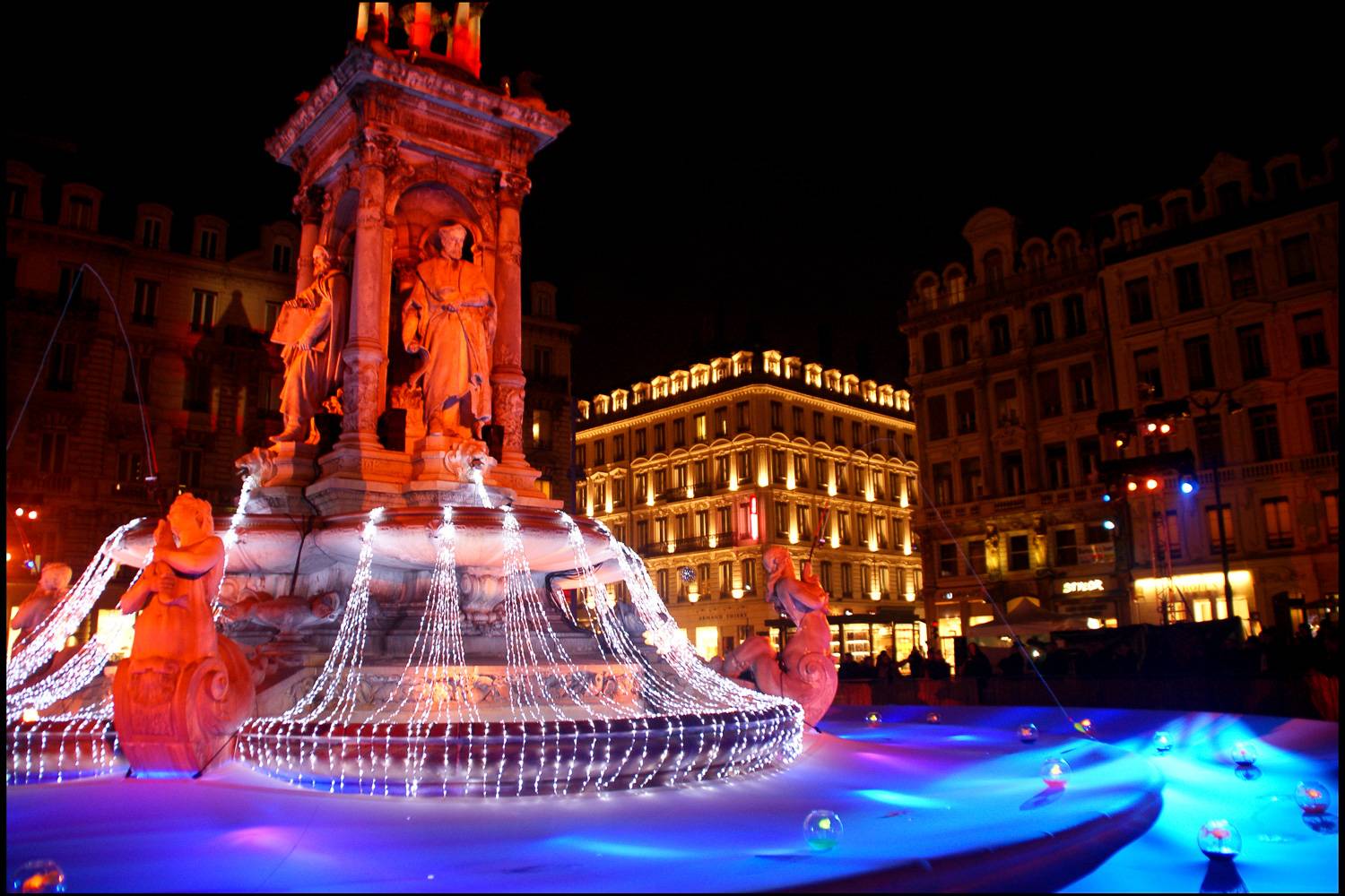 Image of fountain in Lyon decorated with lights for Fête des lumières.