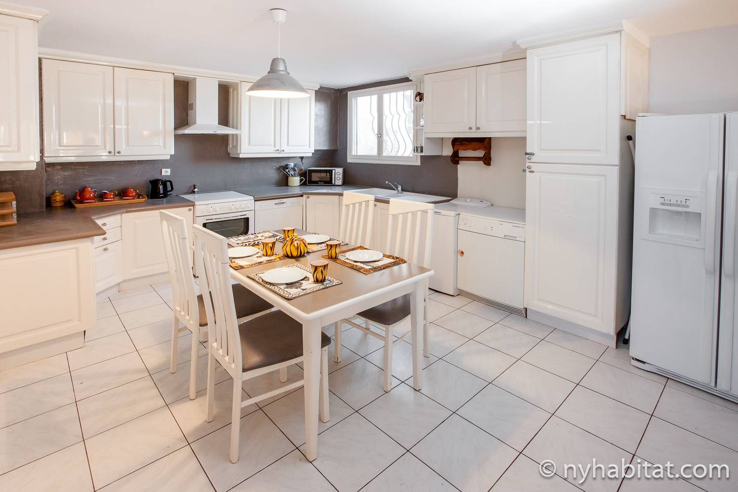 Image of kitchen in PR-1170 with dining table and white cabinets.