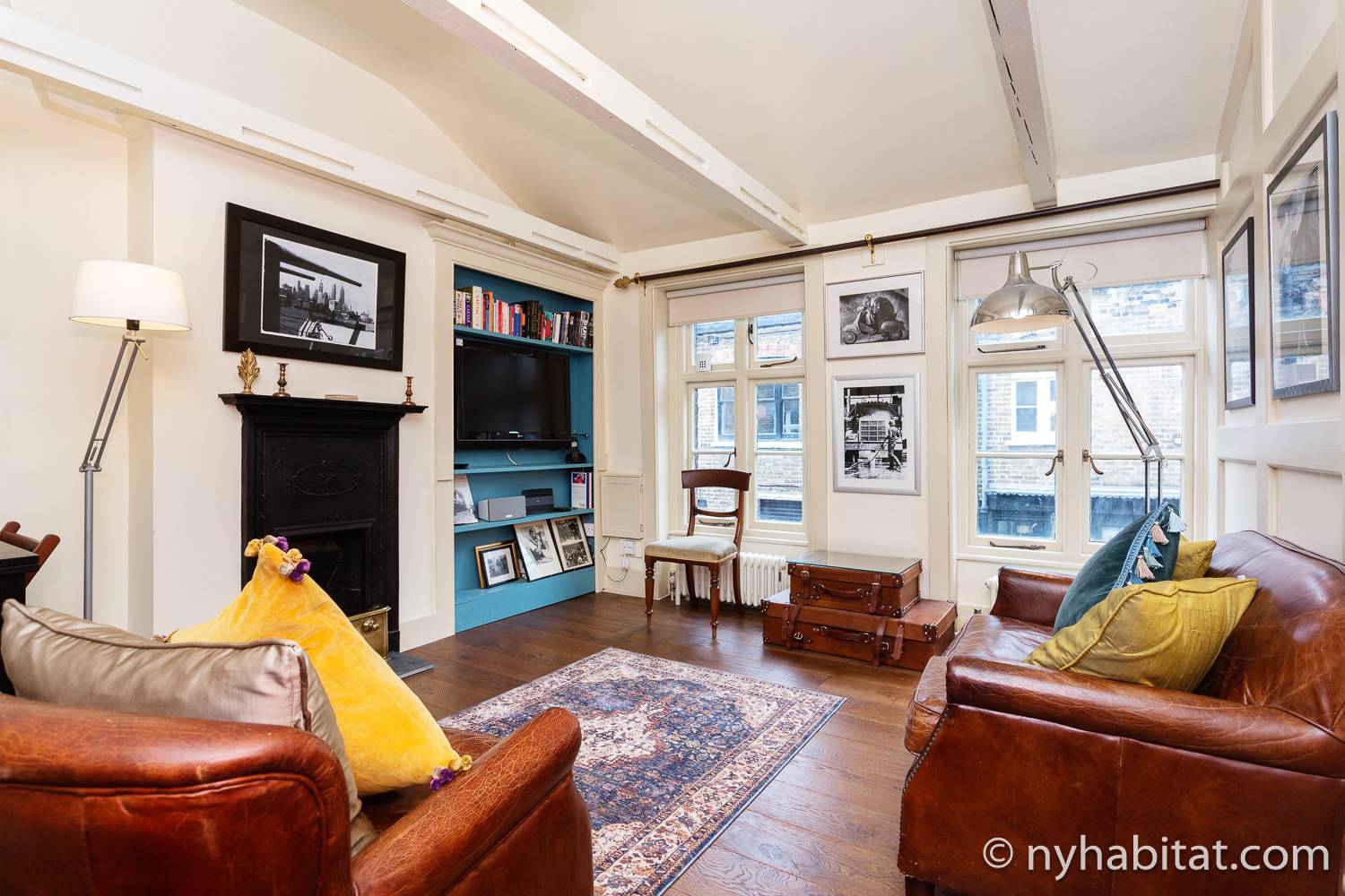 Image of living room of LN-1973 with decorative fireplace, sofas, television, and artwork.
