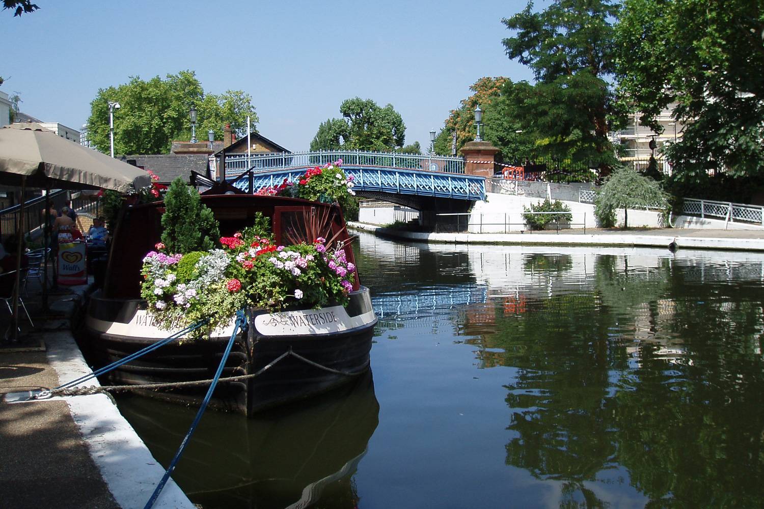 Image of a house boat with flowers docked on Regent’s Canal in London.