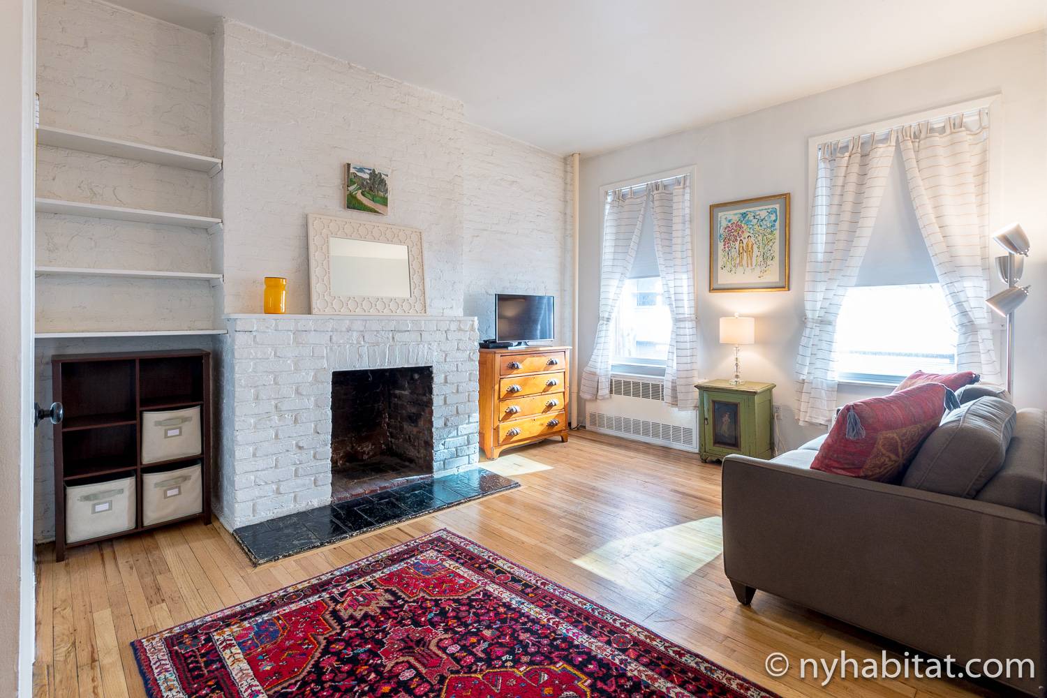 Image of living area in NY-14585 with sofa bed, television and decorative fireplace.