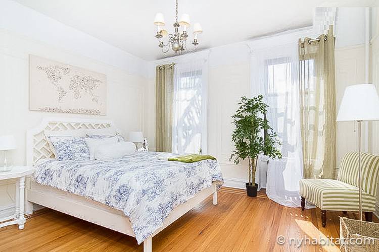 Image of bedroom in NY-16310 with queen-sized bed and potted plant.