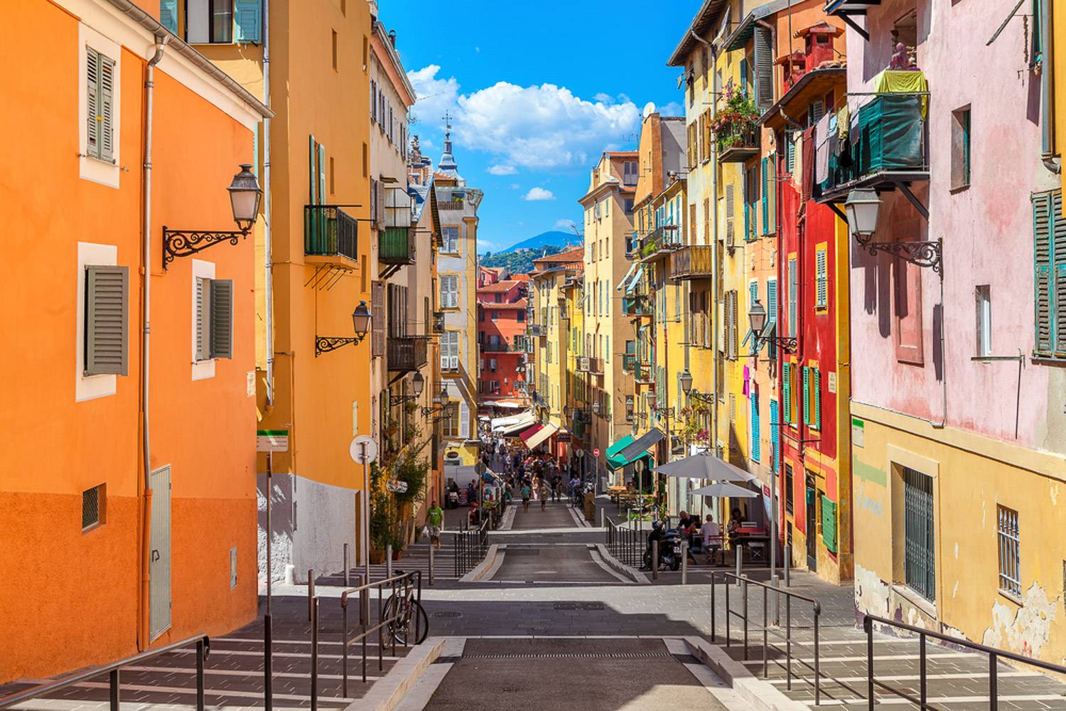 Image of a cobblestone street surrounded by colorful buildings in Old Nice.