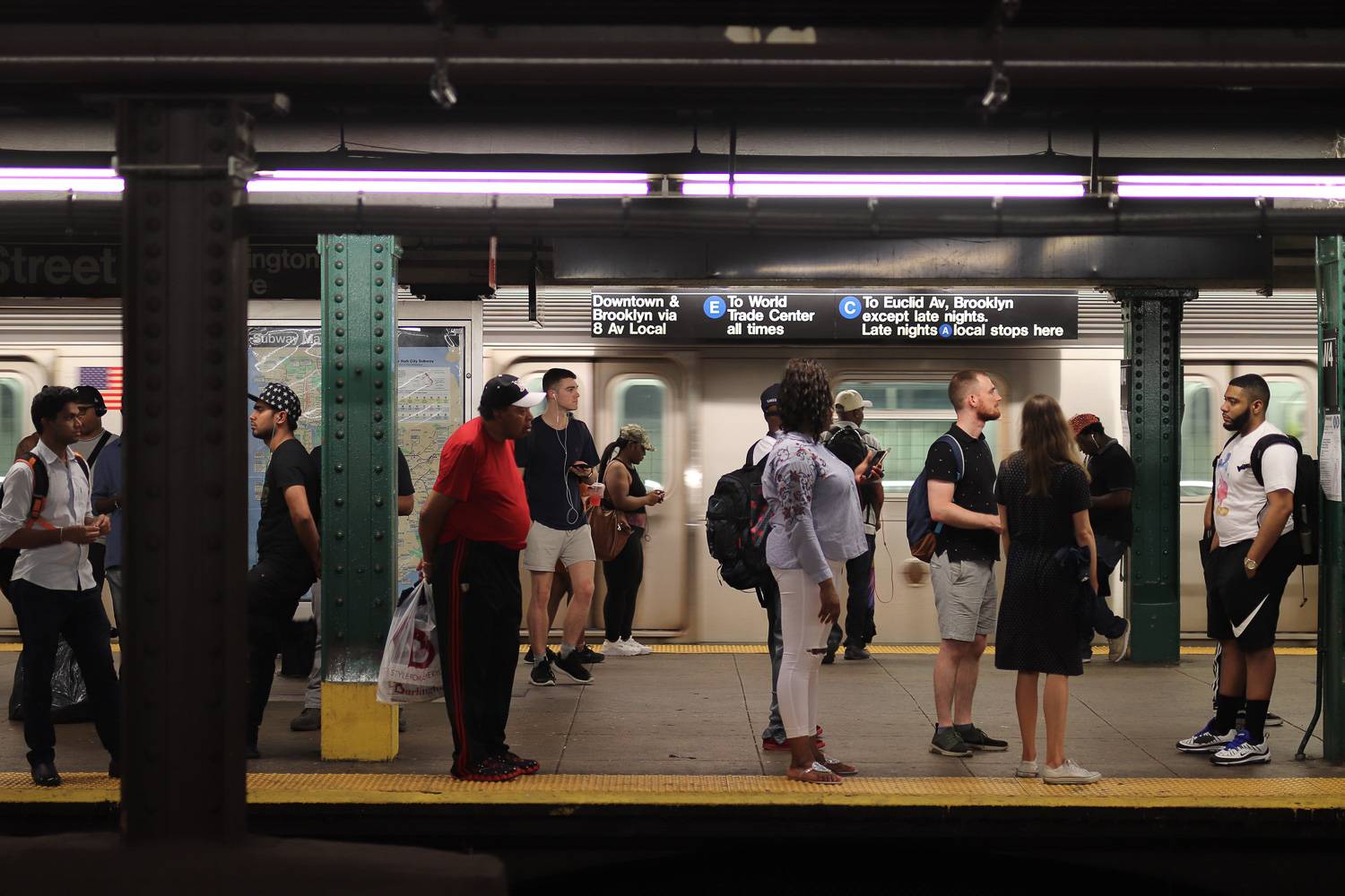 Image of people waiting for the New York City subway in an A/C/E train station.