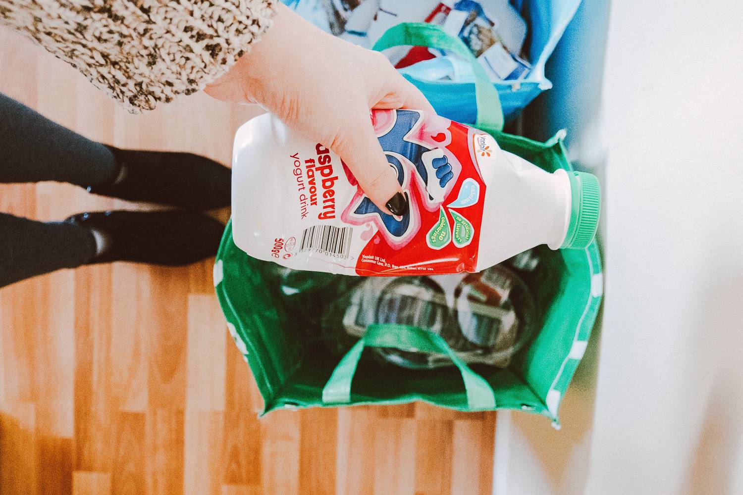 Image close up of a person recycling a plastic bottle.