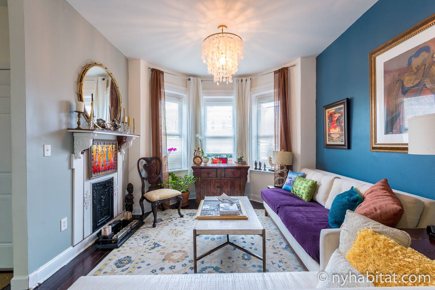 Image of living area of NY-17903 with sofa and decorative fireplace.