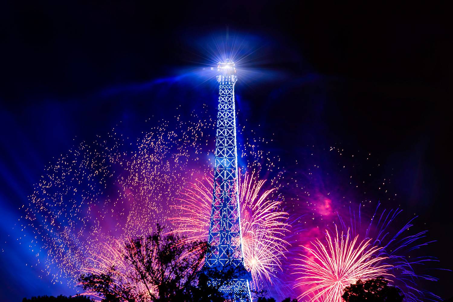 Image of fireworks exploding behind the Eiffel Tower on Bastille Day.