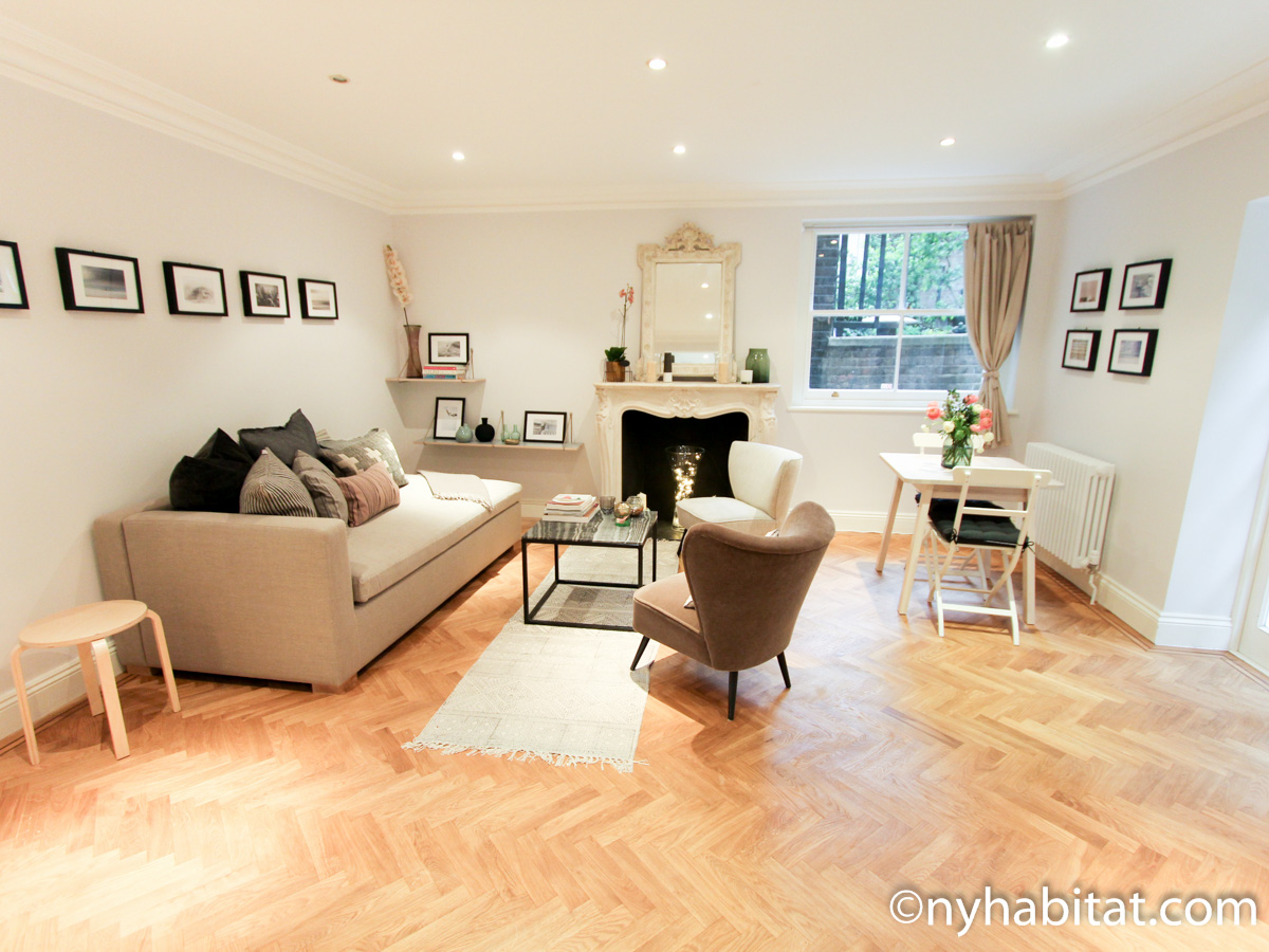 Image of living area in LN-1695 with sofa, armchairs, and decorative fireplace.