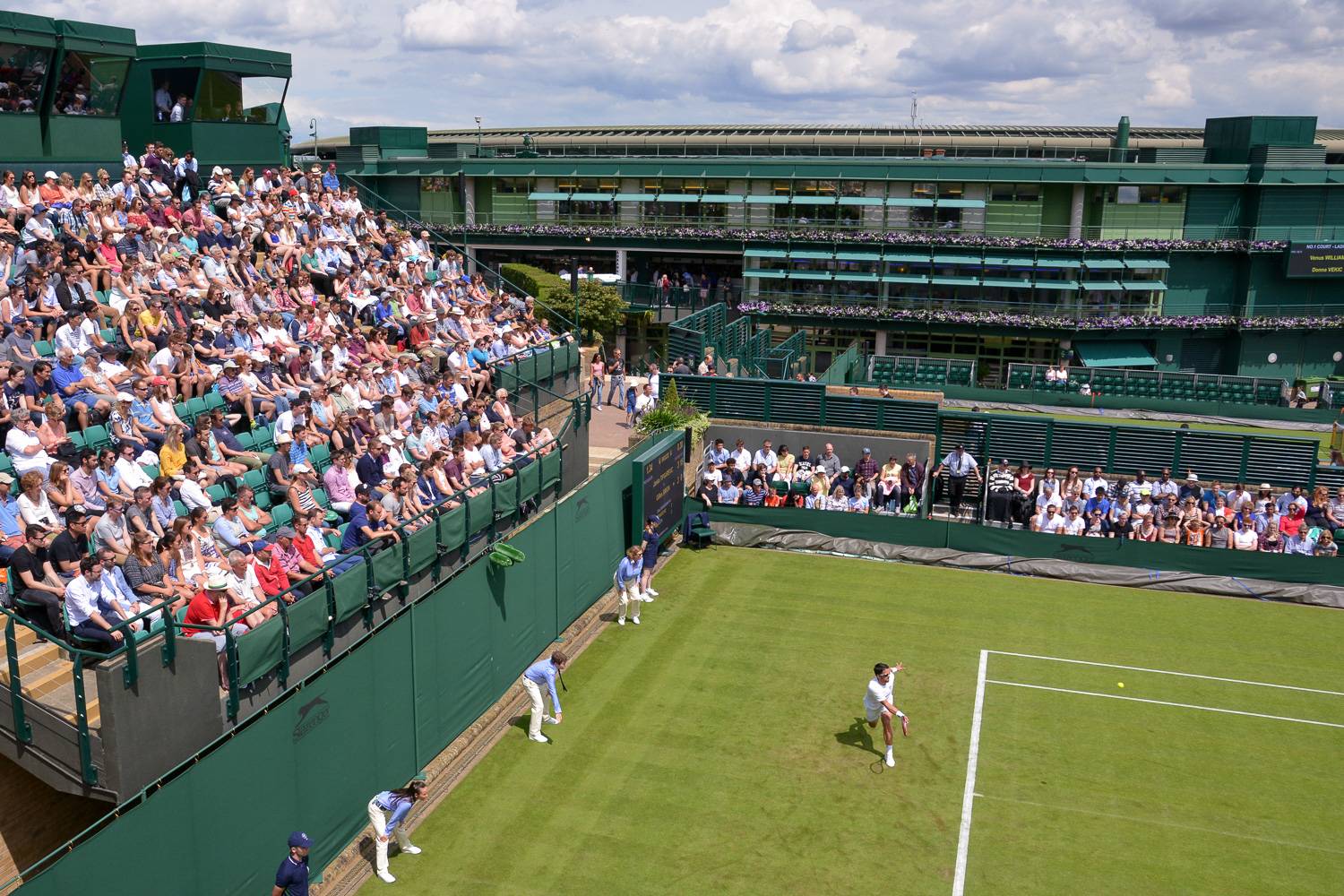 Image of a match and spectators at Court 18 in Wimbledon.