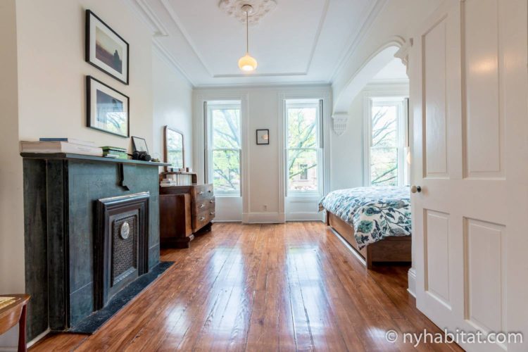 Image of bedroom in NY-15804 with king-sized bed and decorative fireplace.