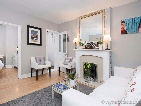 Image of living area in LN-784 with decorative fireplace, sofa, and armchairs.