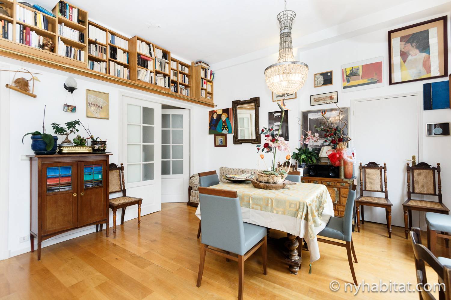 Foto des Wohnzimmers in PA-1460 mit Tisch, Stühlen, Kronleuchter und Bücherregal.