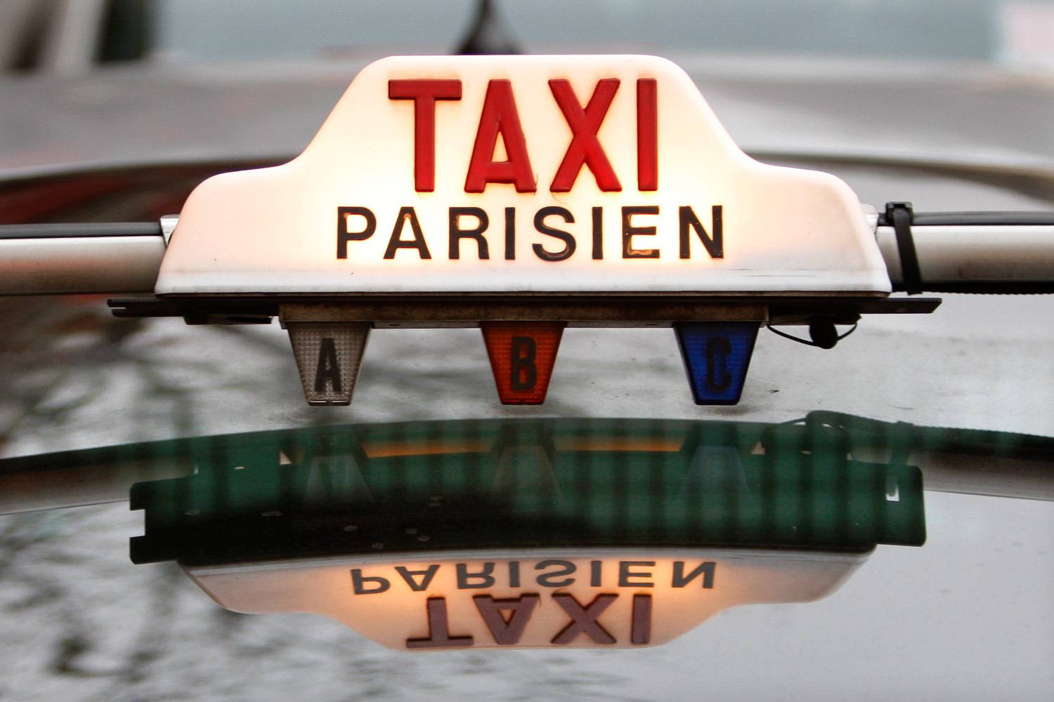 Bild eines beleuchteten Schildes auf dem Dach eines Taxi Parisien.