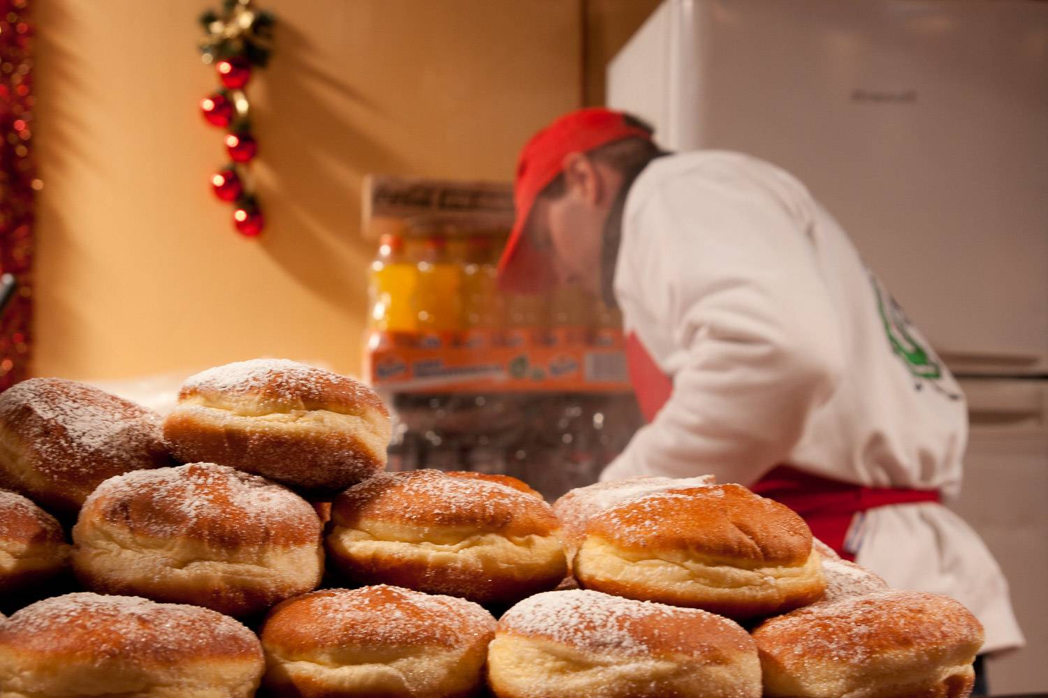 Bild eines Cidre-Donuts im Vordergrund und des Verkäufers im Hintergrund.