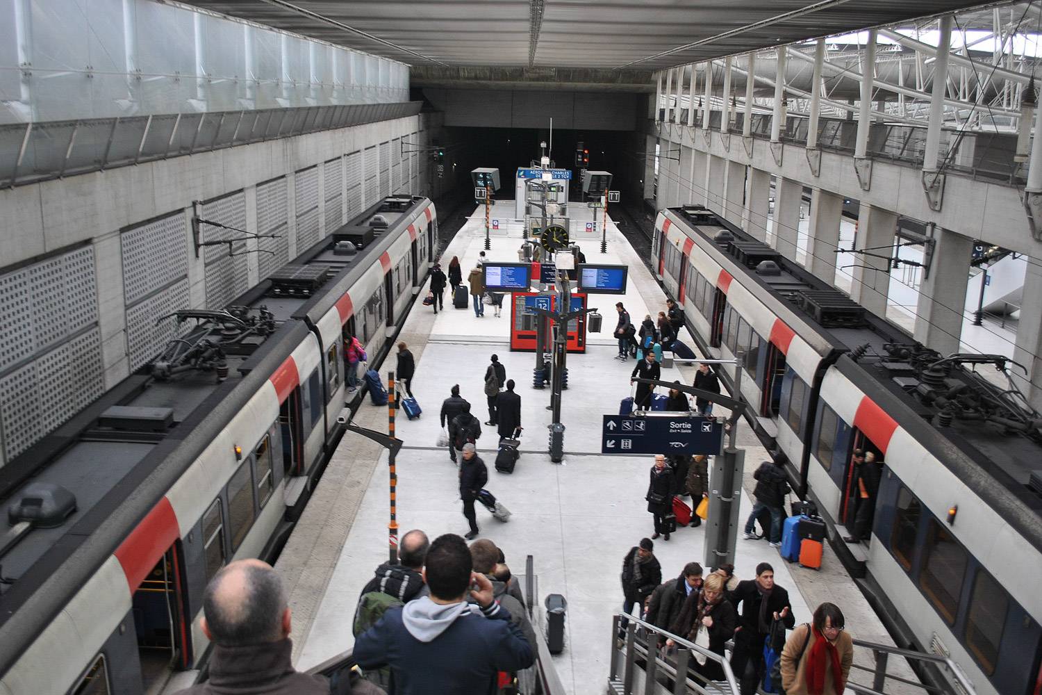Bild von RER-Zügen und Menschen auf dem Bahnsteig eines Bahnhofes in Paris