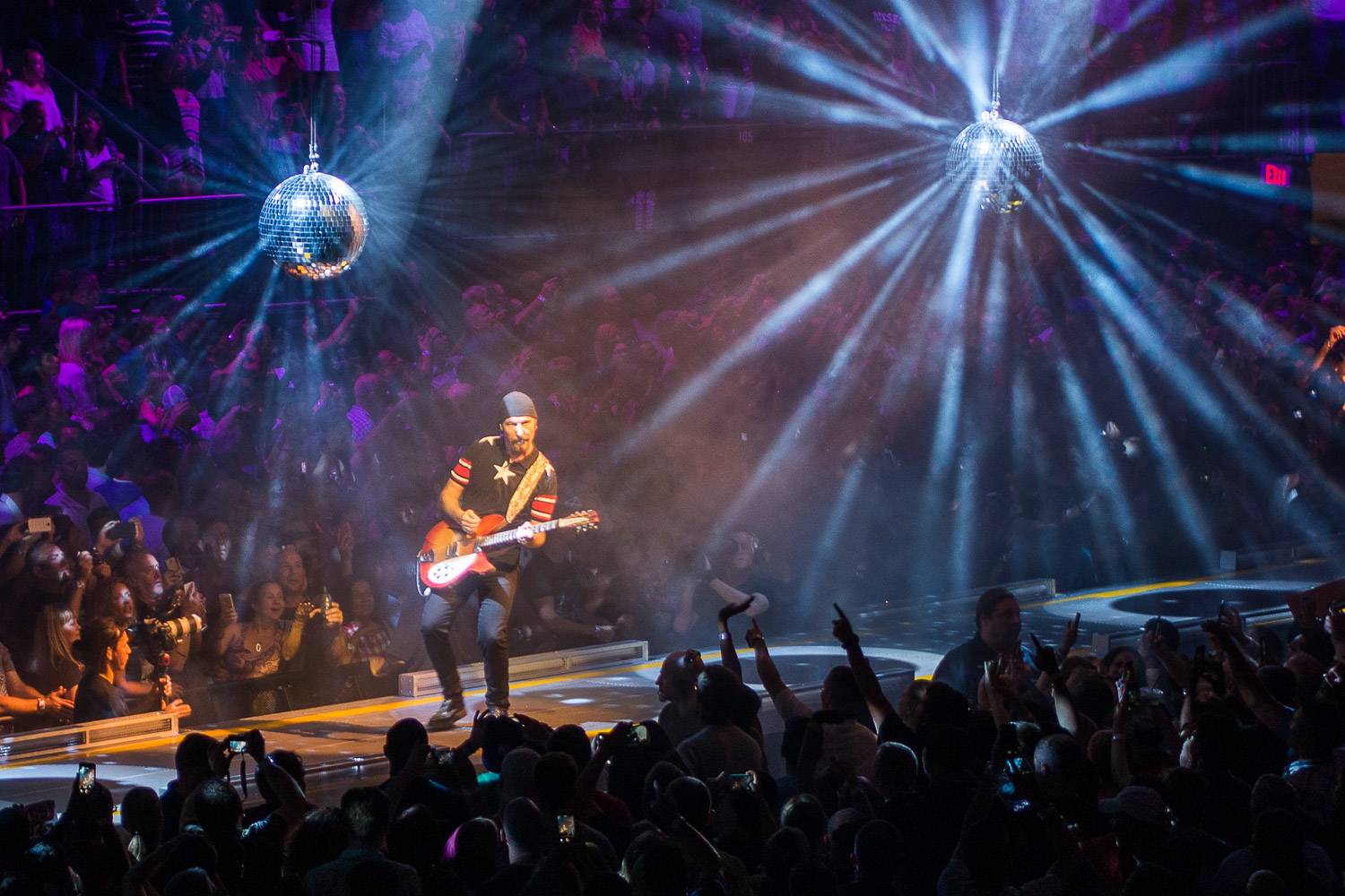 Image du groupe de rock U2 en concert au Madison Square Garden à New York avec des boules à facettes suspendues au plafond