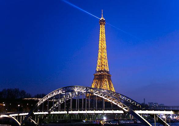 Bild eines leuchtenden Eiffelturms bei Nacht in Paris